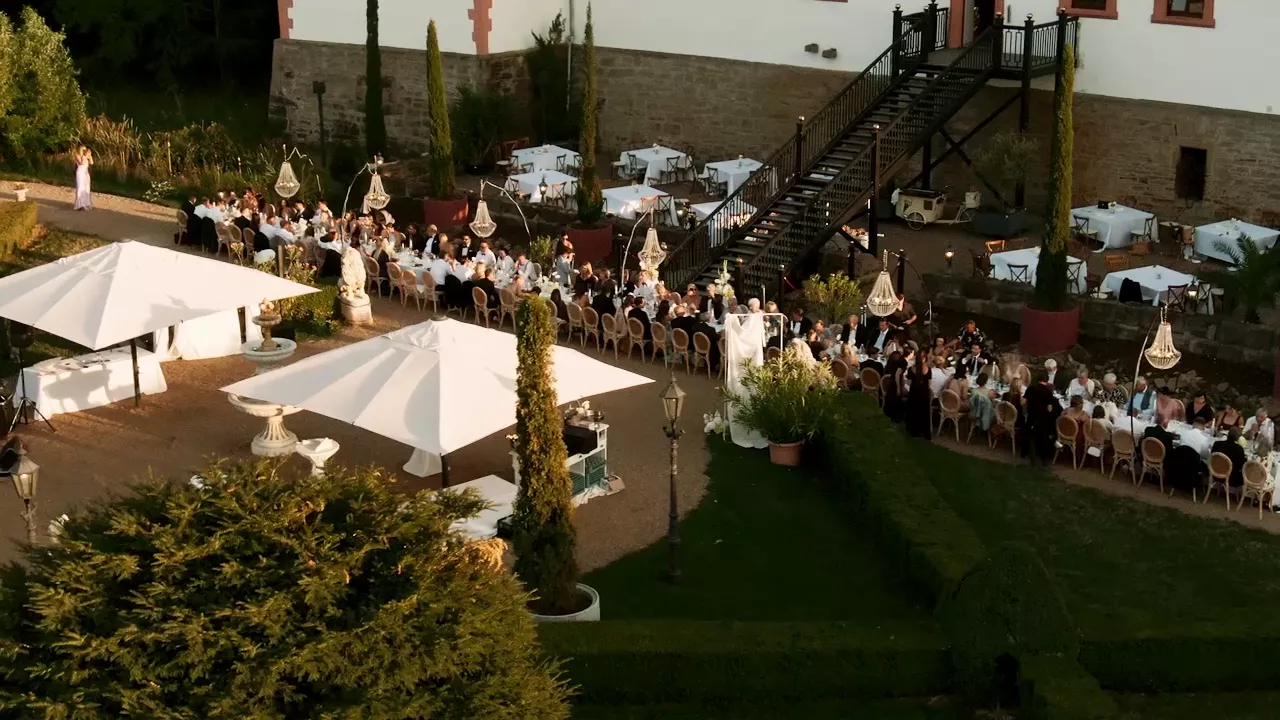 Schloss und lange Toskana-Tafel im warmen Abendlicht